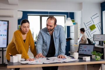 Corporate entrepreneurs meeting to discusss reports during briefing. Diverse team of business people analyzing company financial reports from computer. Successful start up corporate professional