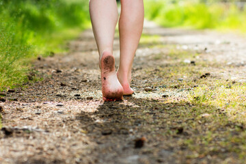 Woman legs walking in summer forest. Barefoot, freedom and health concept.