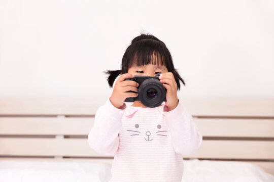 Asian little girl learning to take pictures