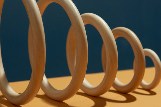 Five wooden rings standing on brown background