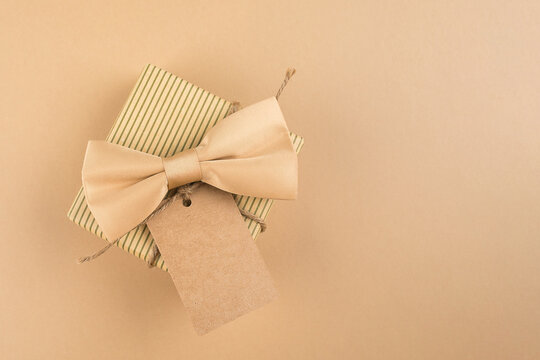 Gift box with label for text on neutral background. Happy Fathers Day concept. Monochrome image