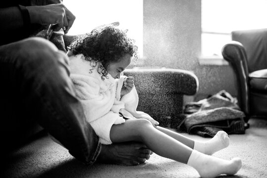 Girl cringes as father sprays her hair