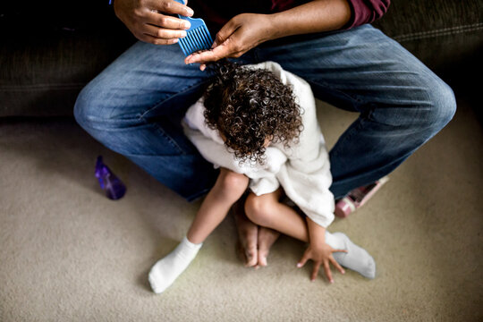 Father picks tangles from daughter's hair