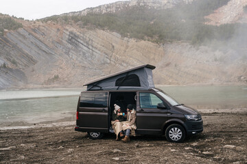 Young couple in a camper van in nature during winter