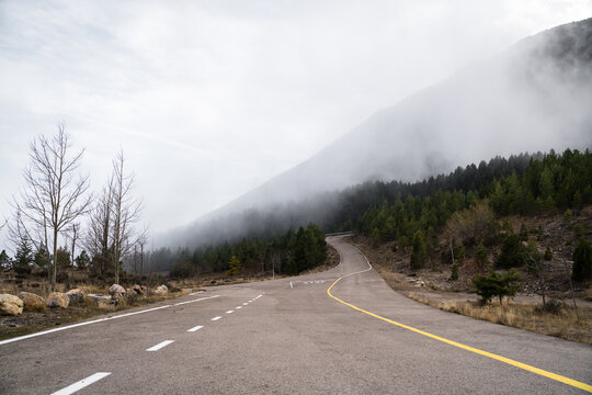Empty mountain road with fog during winter