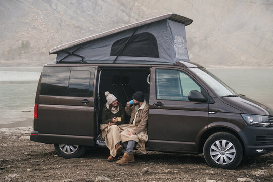 Young couple in a camper van in nature during winter