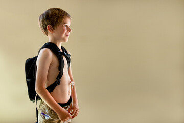 Young boy with gastric tube wearing backpack pump