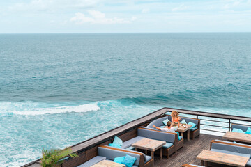 couple sitting in a cafe on the terrace overlooking the ocean