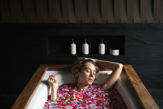 Woman take a bath with petals