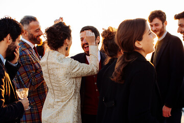 Unrecognizable happy stylish partners celebrating festive occasion in sunlight