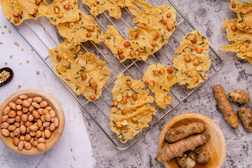 Rempeyek or peyek kacang is a deep-fried savoury Indonesian-Javanese cracker made from flour (usually rice flour) with peanut, lime leaves and other ingredients, bound or coated by crispy flour batter