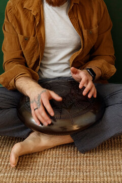 Barefoot man playing percussion instrument
