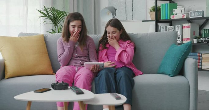 Cute happy girls watching videos online together