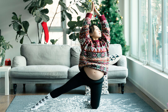 A pregnant woman exercises at home