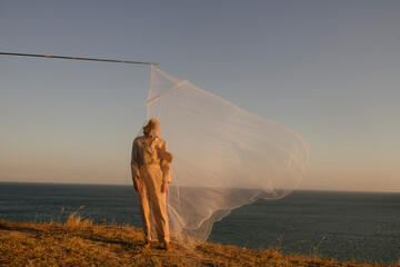woman covered with a mosquito net outdoors