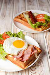 Waffle wholesome breakfast. Sour waffles with grilled sausages, fried eggs, delicious sauce and fresh vegetables.