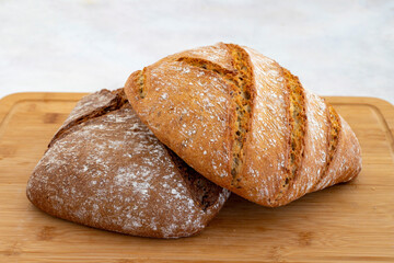 Hot bread fresh from the oven. Wheat bread on wooden background