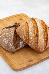 Hot bread fresh from the oven. Wheat bread on wooden background