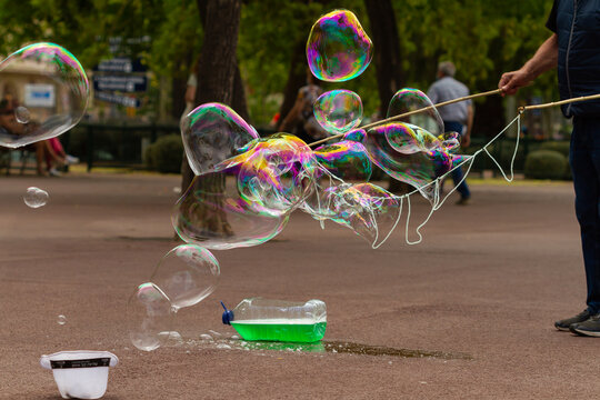 Unrecognizable man making soap bubbles with rope, selective focus.