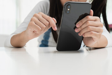 Close up image of an asian little girl using a smartphone.