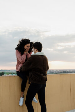 Young girl climbed on the rooftop balcony with her boyfriend