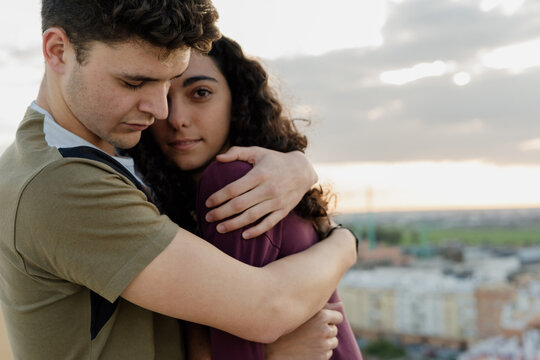 Young guy hugging his girlfriend on the rooftop