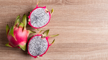 Obraz na płótnie Canvas Dragon fruit or pitaya on wooden background, Tropical fruit, Table top view