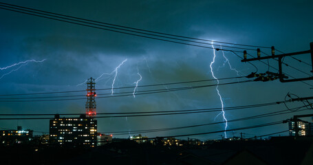 Electric wires during thunderstorm in city