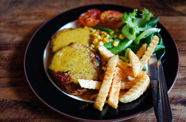 Close up and Focus on French Fries in the Steak main dish in black dish on wood table with the nature light.