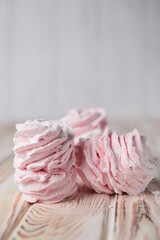 Marshmallow - zephyr on a dark background. Pink fluffy marshmallow with strawberry taste over black.