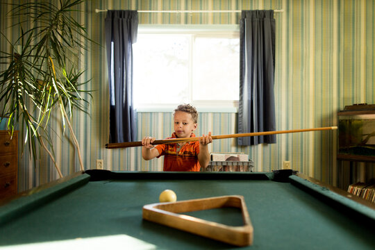 Boy picks up pool cue