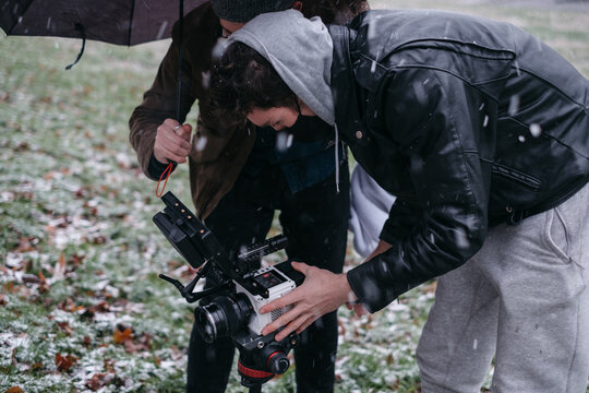 Camera operator and director filming in a field