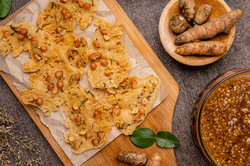 Rempeyek or peyek kacang is a deep-fried savoury Indonesian-Javanese cracker made from flour (usually rice flour) with peanut, lime leaves and other ingredients, bound or coated by crispy flour batter