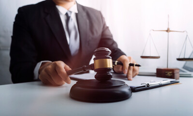 Business and lawyers discussing contract papers with brass scale on desk in office. Law, legal services, advice, justice and law concept picture with film grain effect