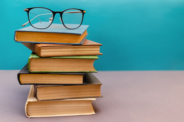 Stack of books with reading glasses on top