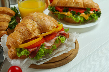 Concept of tasty eating with croissant sandwiches, close up