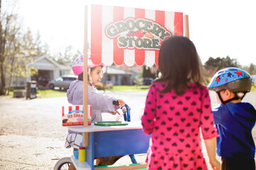 Girl on bike visits friends at grocery stand