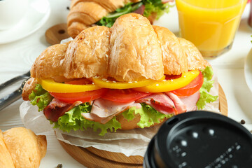 Concept of tasty eating with croissant sandwich, close up