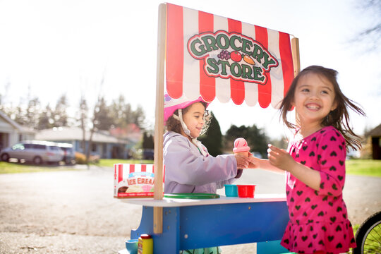 Girl takes pretend icecream cone from friend