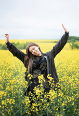 Naklejka na ściany i meble Young girl on yellow rapeseed field