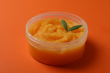 Cosmetic skin care scrub on orange background