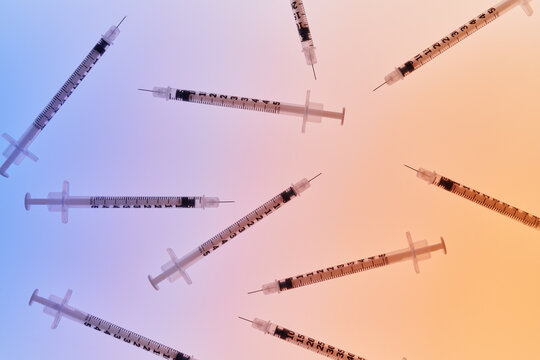 Grouping of Medical Syringes on Blue-Orange Background 