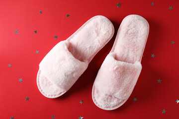 Pair of house slippers on red background