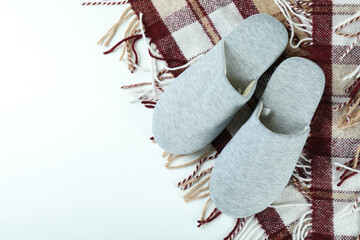 Pair of house slippers and plaid on white background