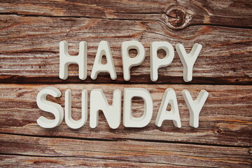 Happy Sunday text message on wooden background