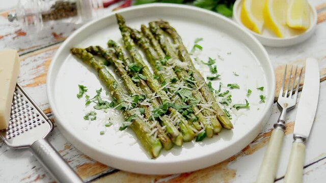 Roasted asparagus with parmesan cheese and parsley. Healthy spring food concept. View from above.