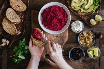 Healthy food : anonymous woman preparing roasted beet hummus toasts
