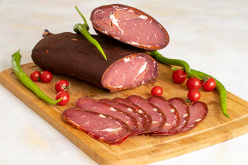 Turkish pastrami on a white background. Whole and sliced pastrami. pastrami is made from the ribeye and beef fillet parts of the cow. Local name pastırma