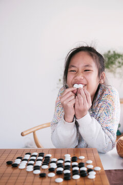 Asian little girl playing Go at home