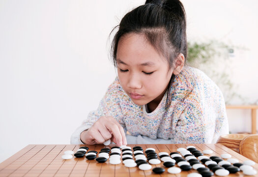 Asian little girl playing Go at home